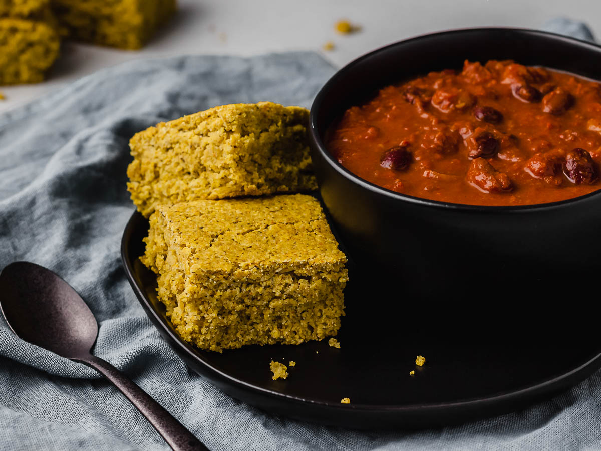 Vegan cornbread served with a bowl of chili.
