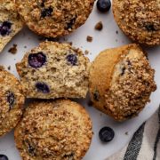 Inside view of a vegan low-fodmap blueberry muffin with whole muffins surrounding.
