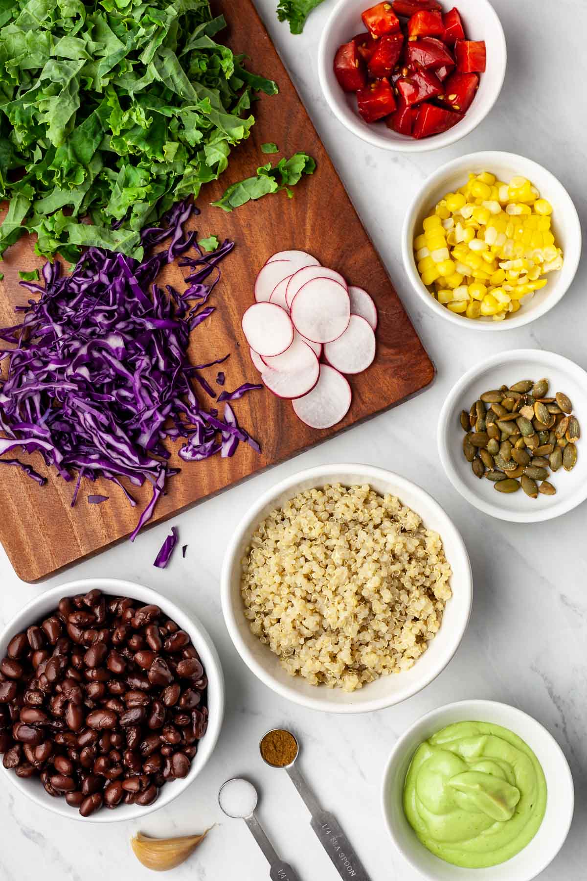 Overhead view of small bowls containing ingredients for a Mexican Buddha Bowl.