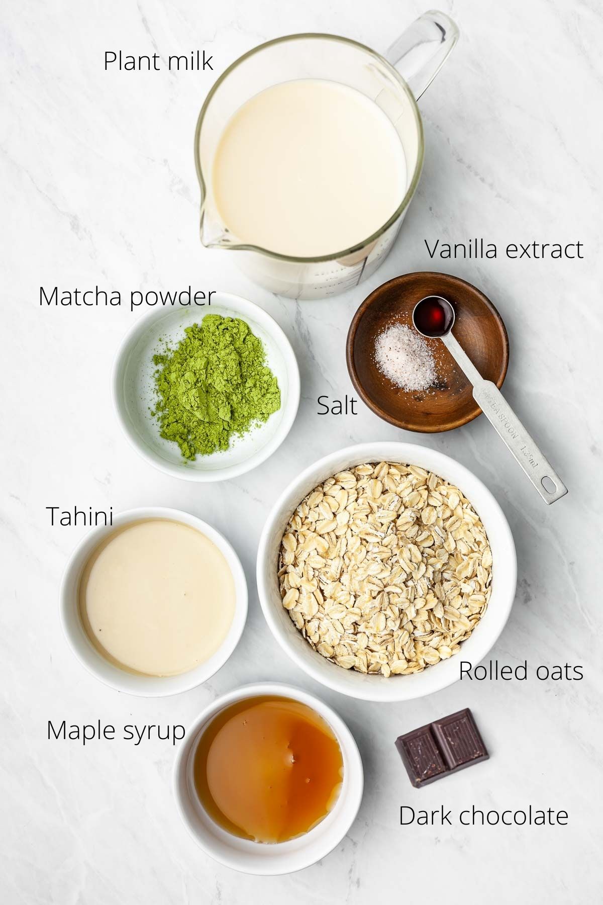 Overhead view of small bowls containing individual matcha oatmeal ingredients.