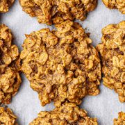 Overhead view of freshly baked vegan peanut butter oatmeal cookies on a baking sheet.