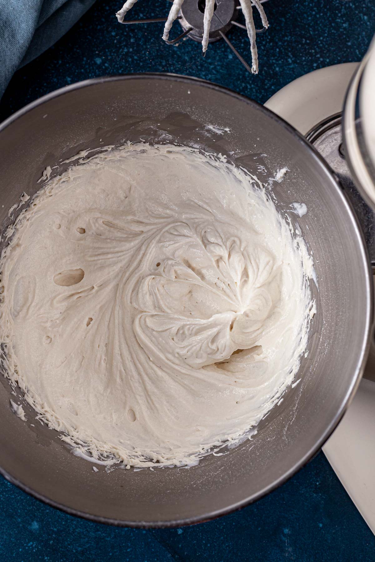 Fluffy dairy-free cream cheese frosting in the bowl of a stand mixer.